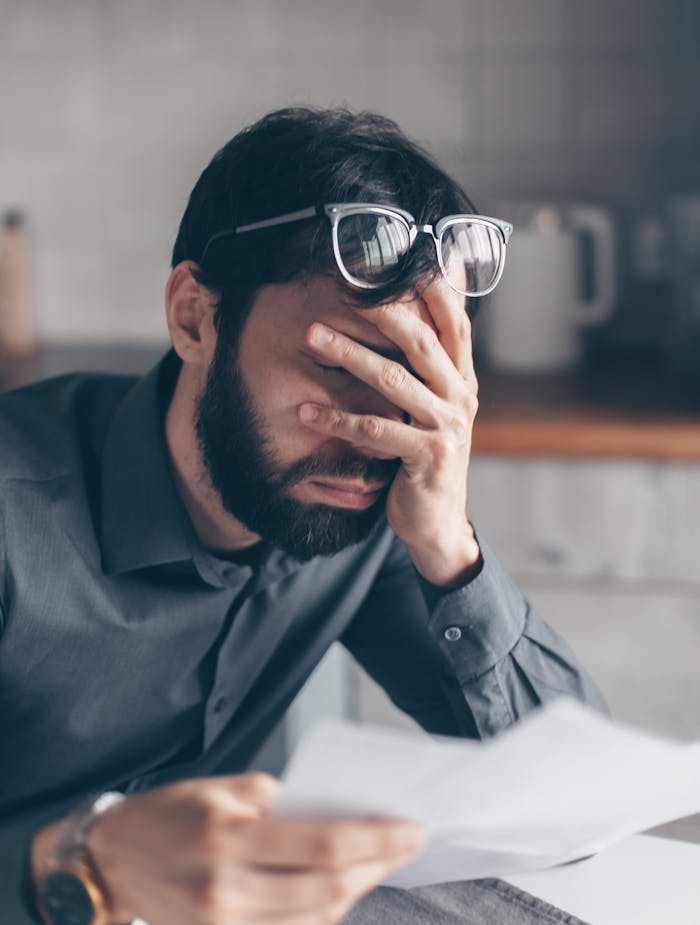 A Man in Gray Long Sleeves Covering His Face